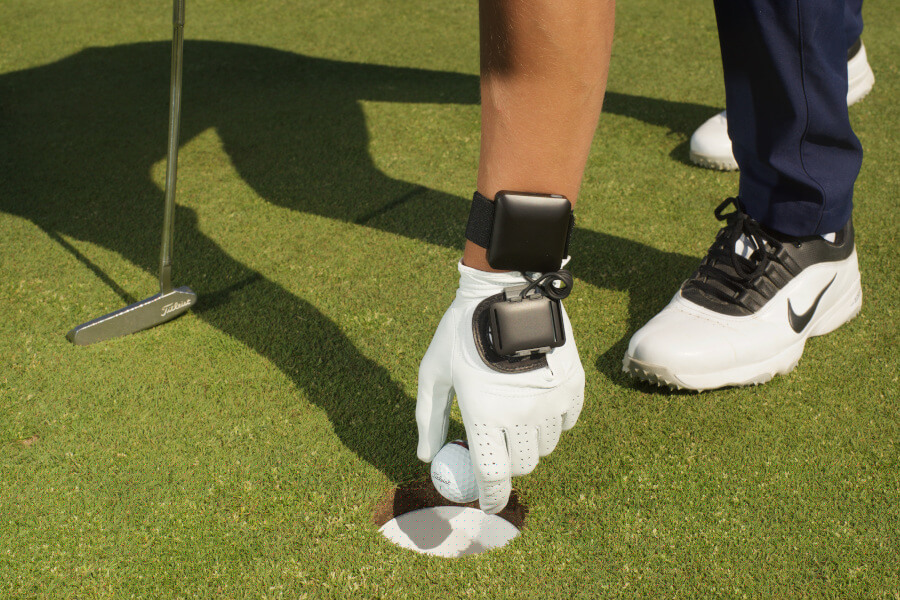 golf player holding ball and wearing glove with HackMotion close up