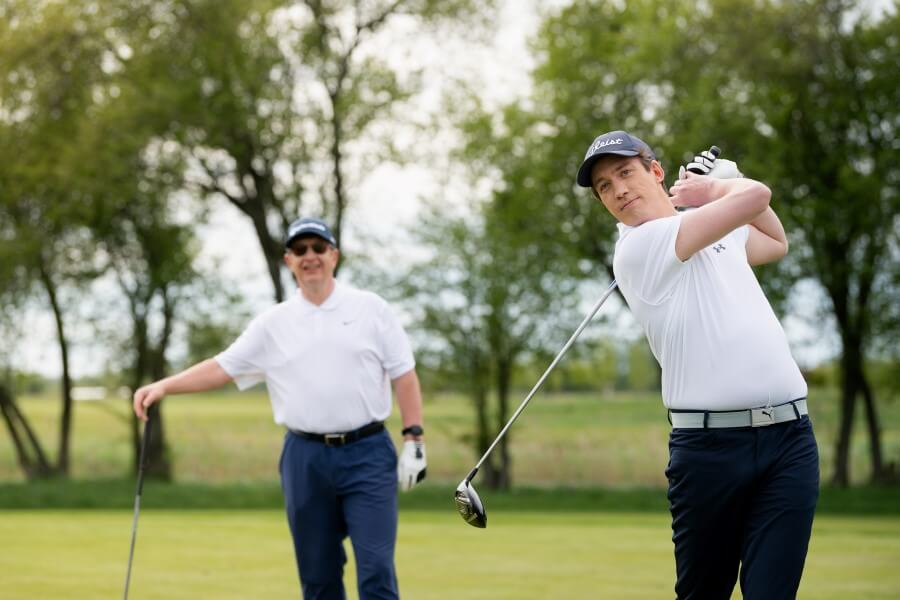 golfer hitting with driver on golf course